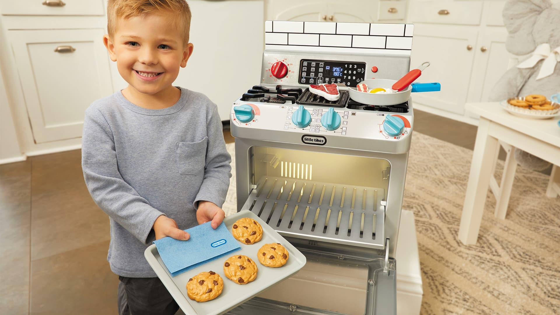 boy playing with toy kitchen set